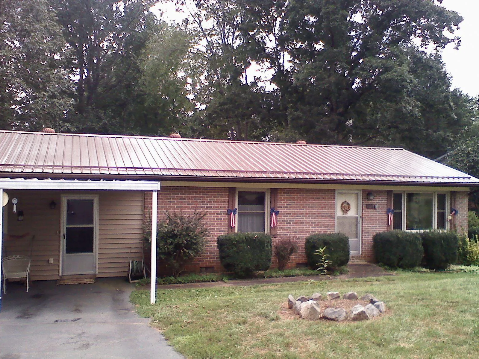Bronze metal roof and carport on a brick ranch home — Roof Repair work by our crew in Clarence